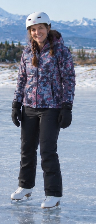 Kickstart Skating Okotoks coach wearing a white helmet and patterned winter jacket